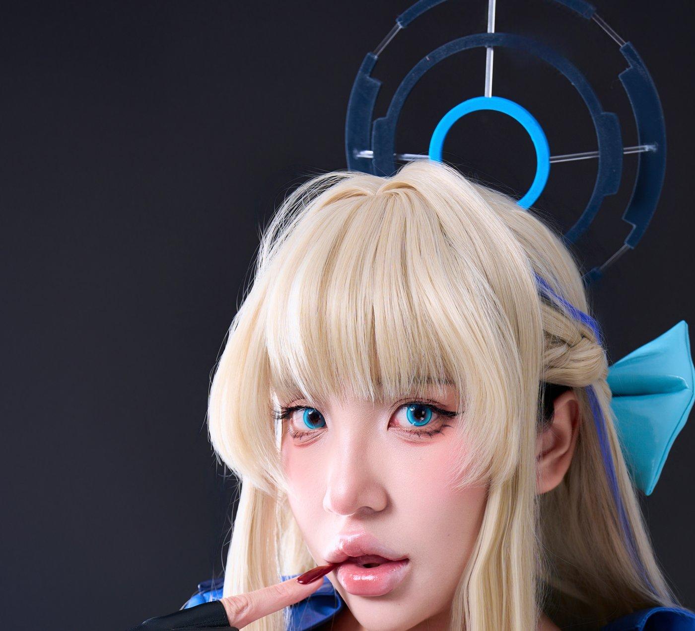 Puy Puy金发上方的蓝黑环形装饰与脸侧手势清楚可见