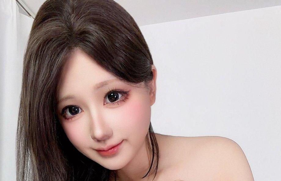 Nyako喵子微微前倾,深色长发落在白墙前,裁自原图002
