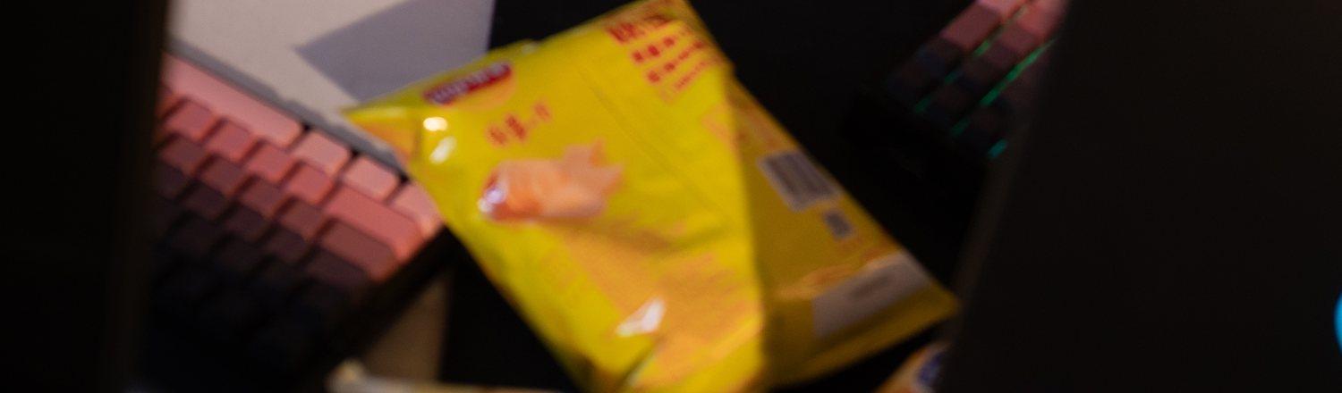 电竞主题中的键盘、桌面和零食包装局部