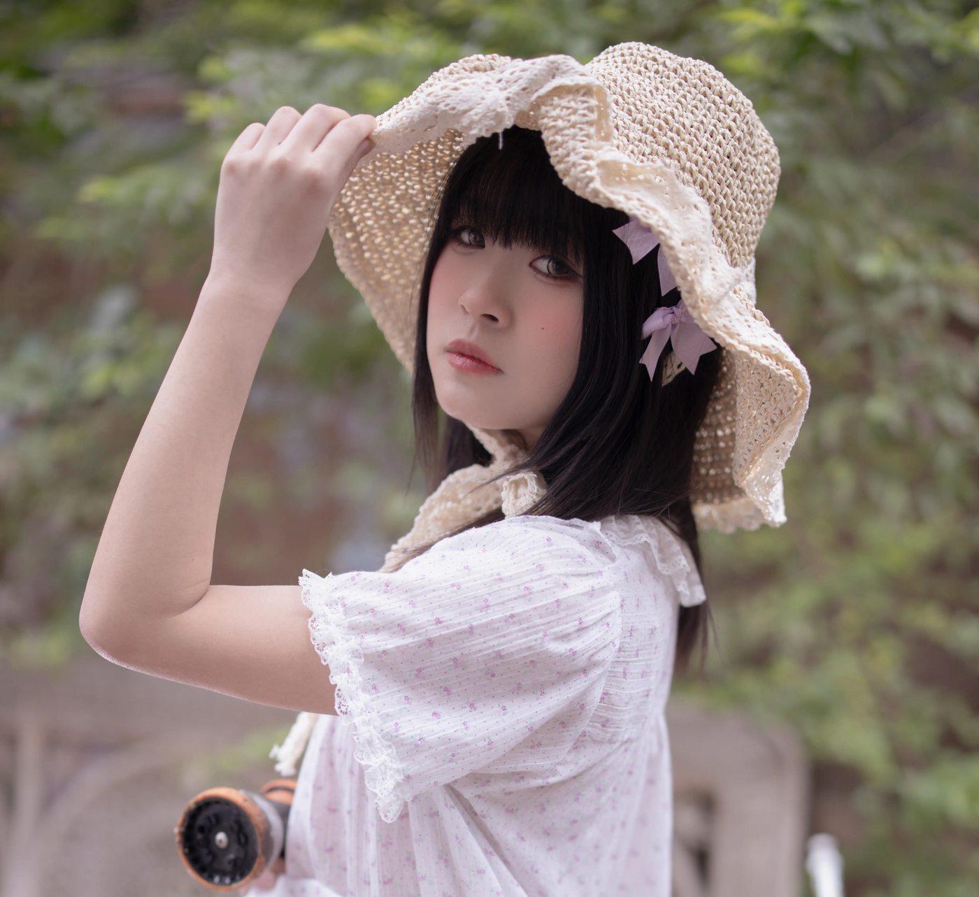 渡久山扶草帽站在绿荫前的夏日侧脸