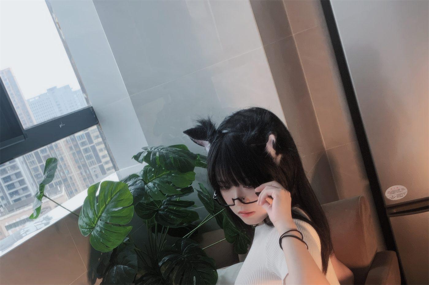 渡久山戴眼镜和猫耳坐在单椅旁