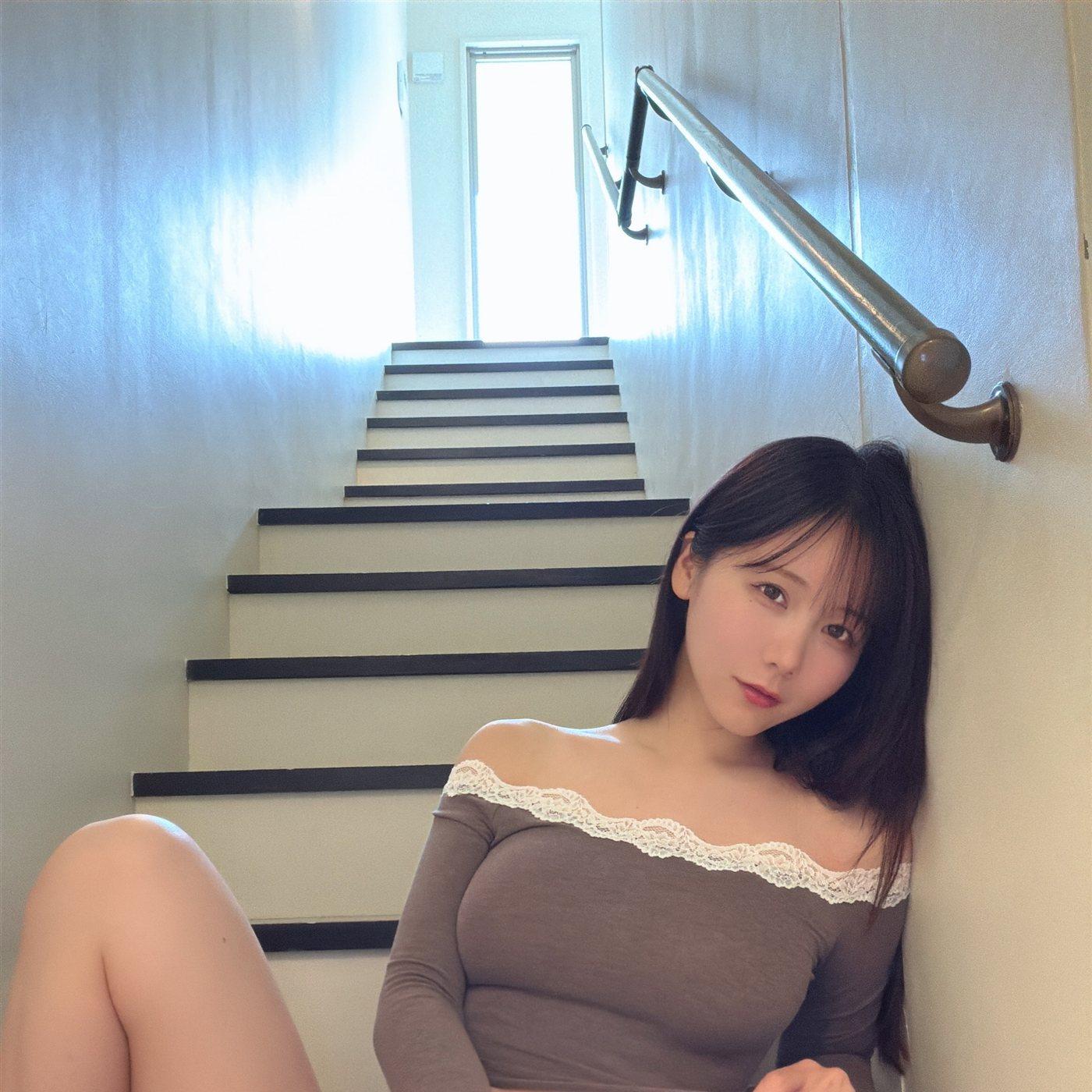 けん研坐在明亮楼梯间